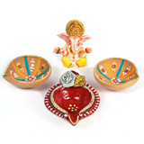 Three large decorated diyas with Ganesh idol