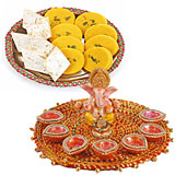 Ganpati idol on a tray with 7 diyas and half kilo sweets