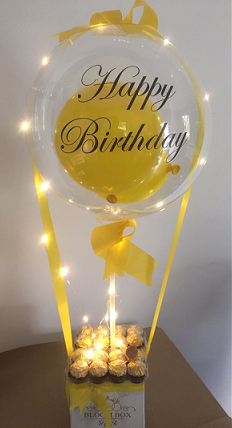 Small yellow balloons inside  Inside a transparent balloon with Fairy lights and 16 Ferrero Rocher yellow ribbons and roses