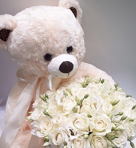 White or cream Teddy with white roses in a basket
