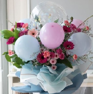 5 Air filled pink white balloons on sticks and 12 gerberas with leaves in a bouquet