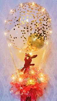 Golden confetti inside the transparent balloon tied to a box with 8 ferrero rocher chocolates in red net with string lights 