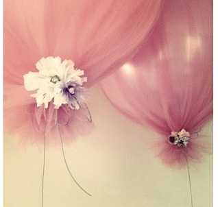 Two clear balloons covered with pink net and flowers