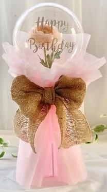 Bouquet of clear printed happy birthday transparent balloon with pink rose in the balloon wrapped in pink and jute bow